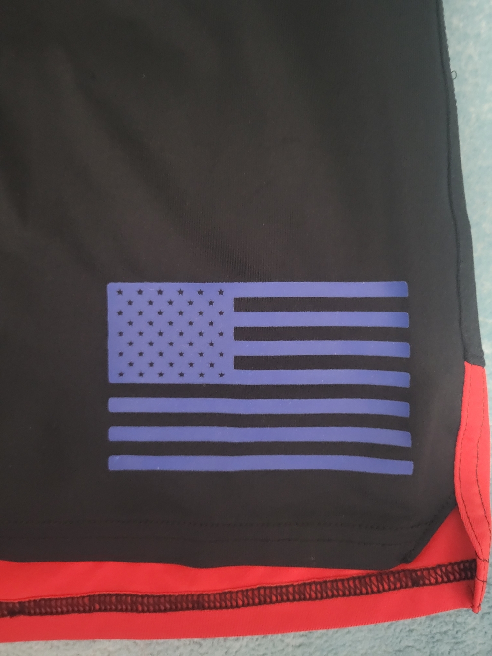 Under Armour Men’s Black Shorts with Red Hem and Blue Flag - Picture 2 of 5